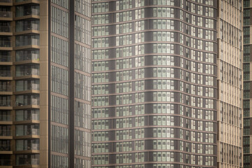 Fototapeta premium Symmetrical glass and metal skyscraper facade with repeating vertical lines.
