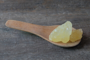 Rock sugar on wood spoon over old wood background.Sweet food.