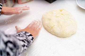 Hands kneading dough on a clean surface in a cozy kitchen during a baking session