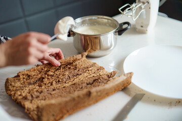 Baking dessert with whipped cream and chocolate cake in a bright kitchen