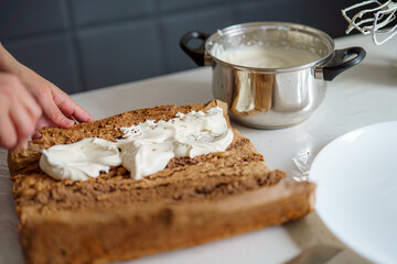 Baking a dessert with cream filling in a cozy kitchen setting during the afternoon