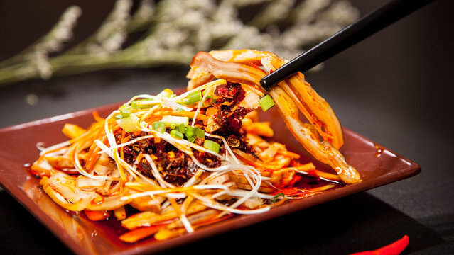 Traditional Chinese Spicy Noodles with Vegetables and Chopsticks in Red Bowl