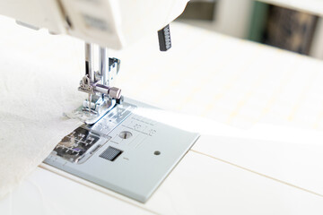sewing machine with a cloth under a steel needle. manufacture of clothing. a household or industrial sewing machine. tailor, couturier. work on sewing designer clothes.