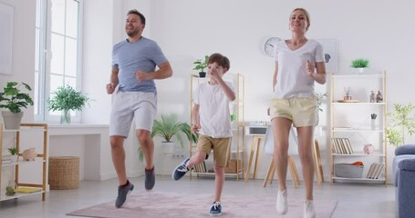 Active, sporty parents and child having a family workout at home. Happy mother, father and son boy doing a jumping exercise together in the living room. Fitness and healthy lifestyle concept - Powered by Adobe
