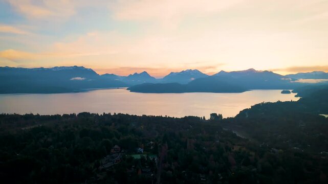 Stunning aerial view of Lake Nahuel Huapi surrounded by morning mist and mountain peaks in Villa La Angostura, Patagonia, Argentina. The scene includes iconic landmarks 