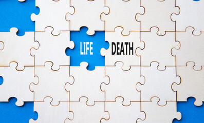 Life or Death symbol. Concept word Life or Death on wooden puzzle. Beautiful blue background....