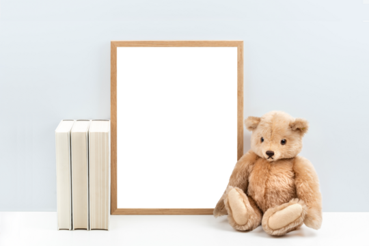 minimalist nursery art mockup with blank wooden picture frame and a vintage teddy bear / children's toy and books  on a white shelf or desk against a light blue wall, simply insert your artwork
