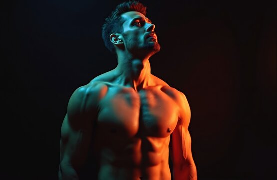 Muscular man with strong shoulder muscles on black background. Bodybuilder portrait with sexy attitude, confident stare. Male model posing undressed, handsome person with manly physique.