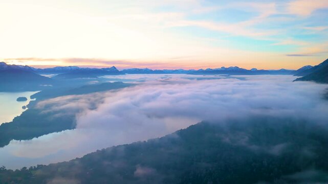 Stunning aerial view of Lake Nahuel Huapi surrounded by morning mist and mountain peaks in Villa La Angostura, Patagonia, Argentina. The scene includes iconic landmarks 