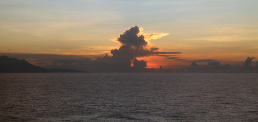 Tropical sunrise with rain clouds on horizon