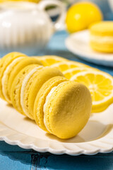 Delicious lemon macarons with fresh lemon slices on white plate