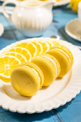 Lemon macarons with lemon slices resting on elegant white plate