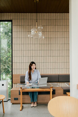 Portrait of a freelancer working in a shop. Beautiful Asian woman working in a coffee shop.