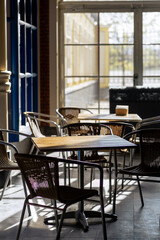 Cozy Indoor Cafe Setting With Tables and Chairs Bathed in Warm Sunlight During the Morning Hours