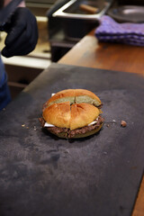 hamburguesa recien elaborada partida en trozos en la tabla de piedra de pizarra de la cocina