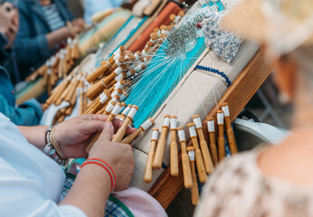 Bobbin lace making in Galicia, Spain — traditional lace-producing art. An elderly woman crafting beauty in a modern-day Spanish town square.