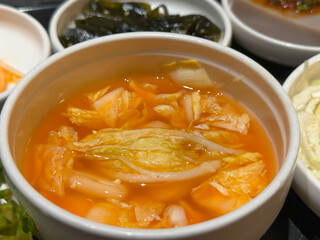 Korean watery kimchi in white bowl, tangy and refreshing, fermented traditional food