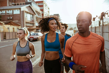 Diverse group of young people running together in the city