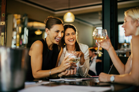 Group of businesswoman having wine in a cafe bar after work