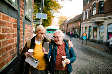Happy senior couple taking selfie on vacation in European city street