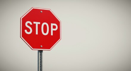 Obraz premium A stop sign red with white lettering is centered against a neutral background on a metal pole