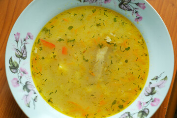 Warm chicken soup served in a floral bowl during a cozy afternoon