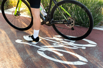 Naklejka premium Professional cyclist standing on bike lane symbol with racing bicycle