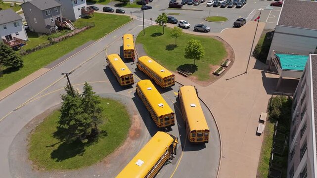 Aerial View This Peaceful Scene Shows Yellow Buses Parked In A Circular Path Around A School Campus In Halifax, Awaiting Their Daily Pickup Of Children On A Bright, Sunny Summer Afternoon.