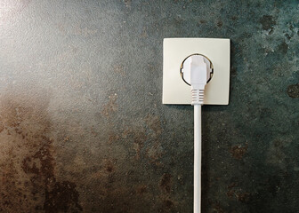 White Power Plug Inserted into Wall Socket on Textured Background