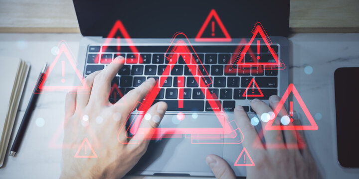 Hands typing on laptop keyboard with multiple red exclamation mark warning icons overlaid, symbolizing cyber alert or online fraud threat concept.