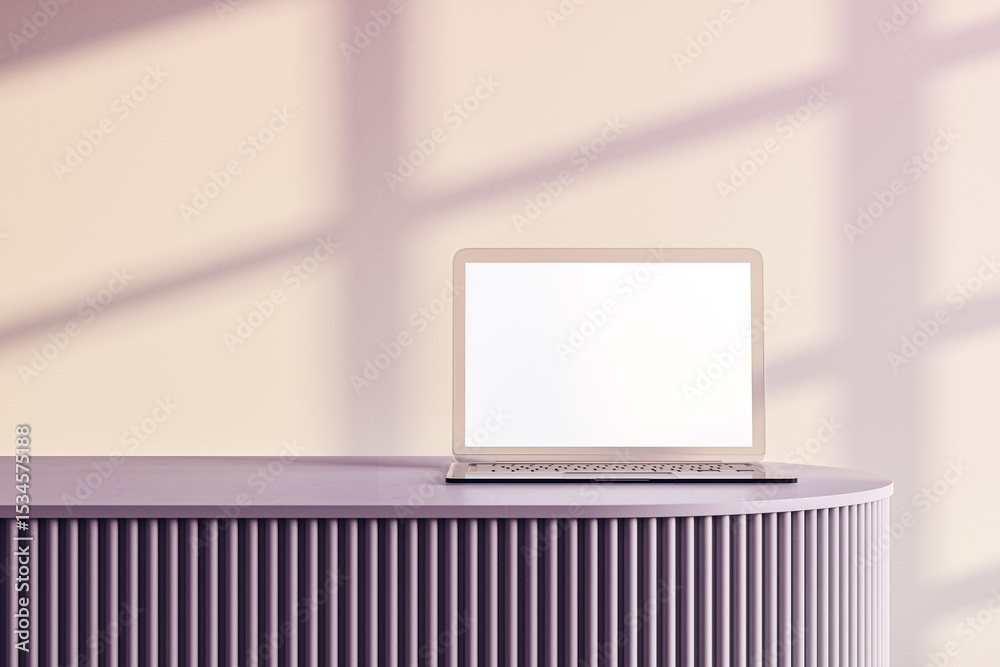 Poster laptop on modern round podium with blank screen in sunlight casting shadows on wall in minimalist st