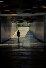 Fototapeta premium Silhouette of a woman walking in a tunnel