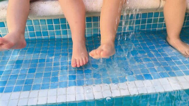 Pies de ni&ntilde;os jugando en piscina cristalina