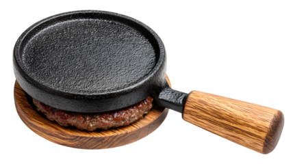 Close-up shot of a sizzling cooked hamburger patty on a small cast iron skillet resting on a wooden trivet against a dark background