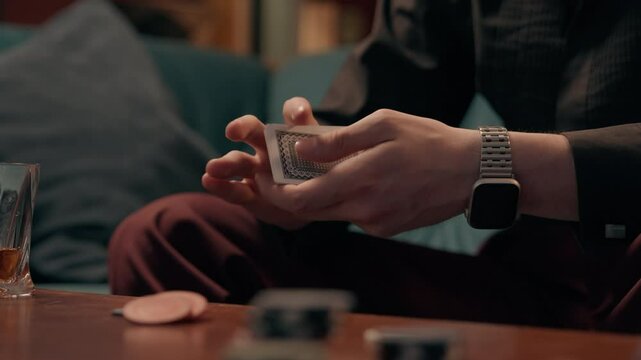 Unrecognizable Caucasian man dealer gamer croupier guy male hands shuffles playing cards shuffling card betting play game strategy luck poker tournament indoors living room casino. Gambling addiction