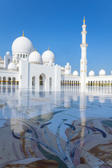 Obraz premium View of Sheikh Zayed Grand Mosque in Abu Dhabi made of white marble with flowers made of precious stones in design and beautiful reflections. Vertical photo