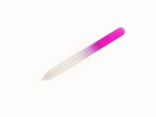 Glass nail file with pink handle resting on a white surface in bright lighting