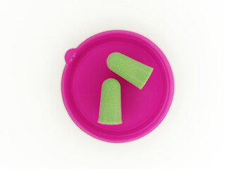 Earplugs placed on a bright pink container designed for noise reduction during sleep or loud environments