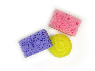 Colorful sponges in purple, pink, and yellow arranged on a clean surface for household cleaning tasks