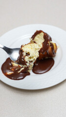 Close-up of a slice of New York-style cheesecake on a white plate.