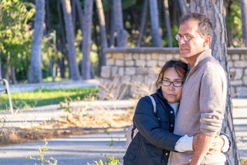 Fototapeta premium Couple sharing a quiet moment in a sunlit park surrounded by tall trees