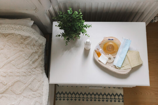 Medical tray with a colostomy bag and medicines.