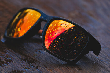 Colorful Reflective Sunglasses with Water Droplets on Wood