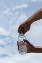 水のペットボトルを開ける人
