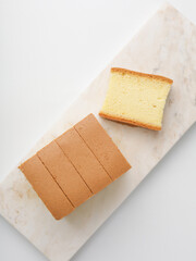 Sliced vanilla cake on white background