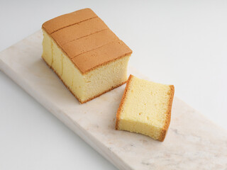 Sliced vanilla cake on white background