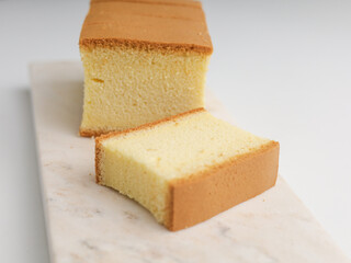 Sliced vanilla cake on white background