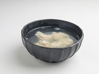 Tofu cooked in clear soup, isolated on white background