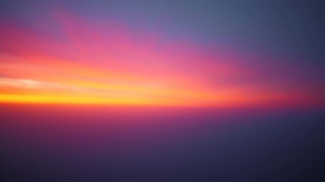 Vibrant sunset with gradient of warm yellow to deep purple, softly blurred landscape at dusk or dawn, horizon line, atmospheric sky.