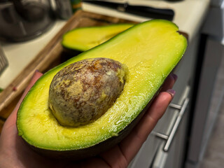 Close-Up of Ripe Avocado Half with Seed in Hand